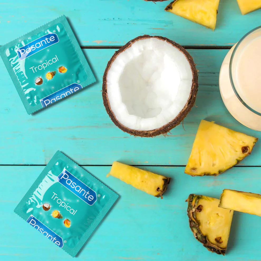 Pasante Tropical condoms with coconut, pineapple, and smoothie on a turquoise background